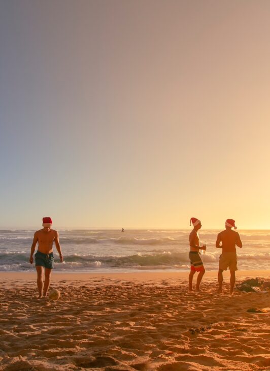 a group of people standing on top of a sandy beach