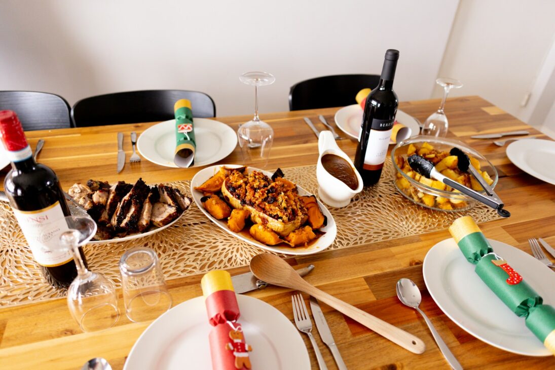 a wooden table topped with plates of food and wine
