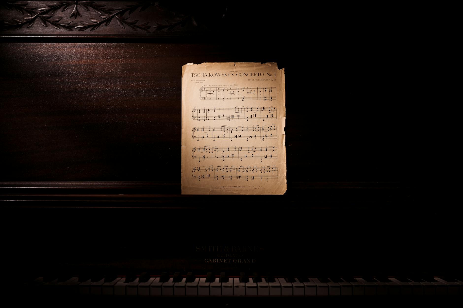 photo of music notes leaning on wooden piano