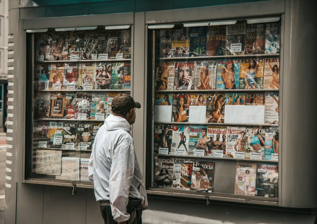 a man standing in front of a newspaper stand