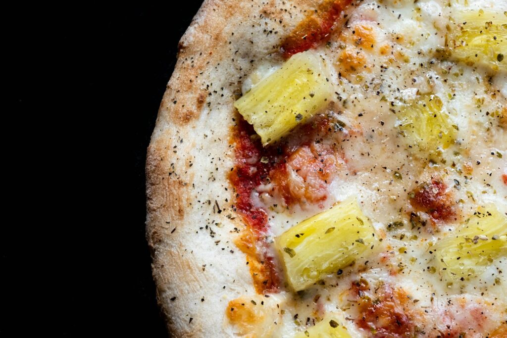 a close up of a pizza with pineapples on it