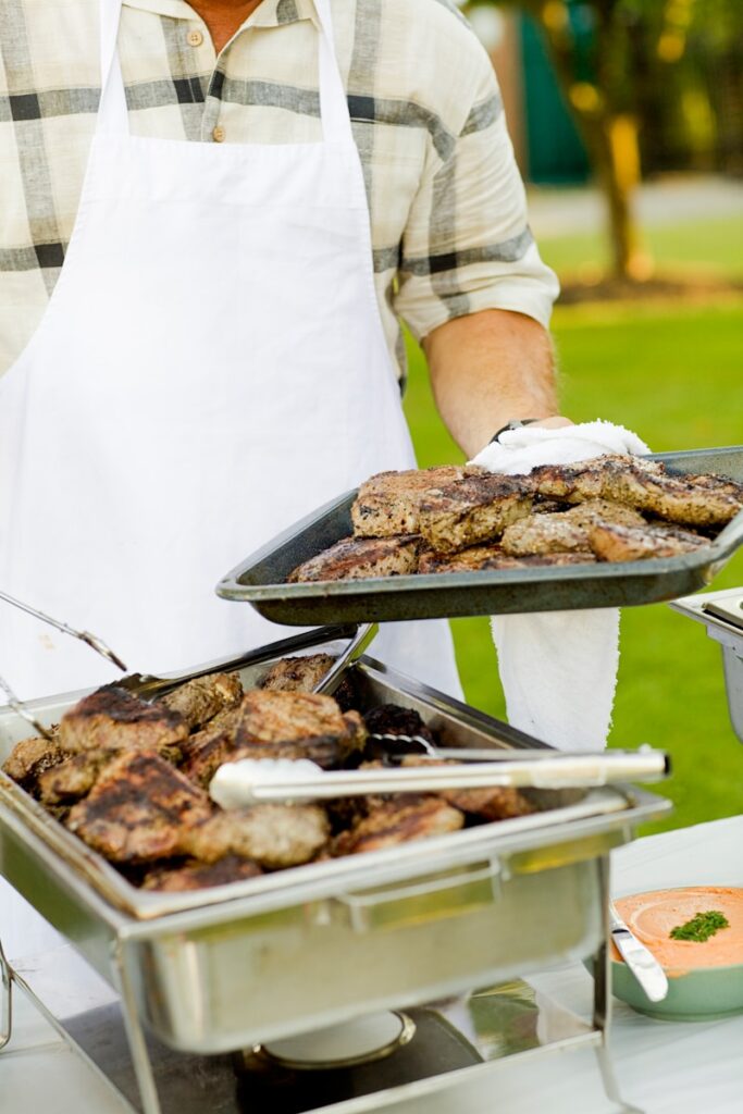 person holding tray filled with grilled meat