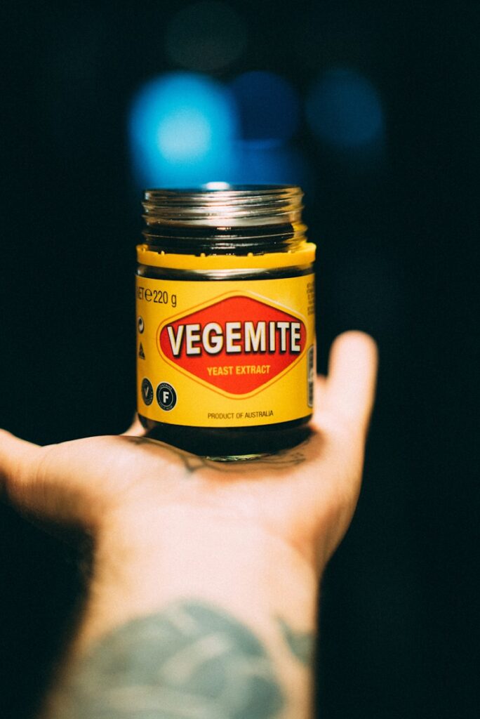 person holding yellow and black bottle. Vegemite Recipes Every Australian Needs to Try