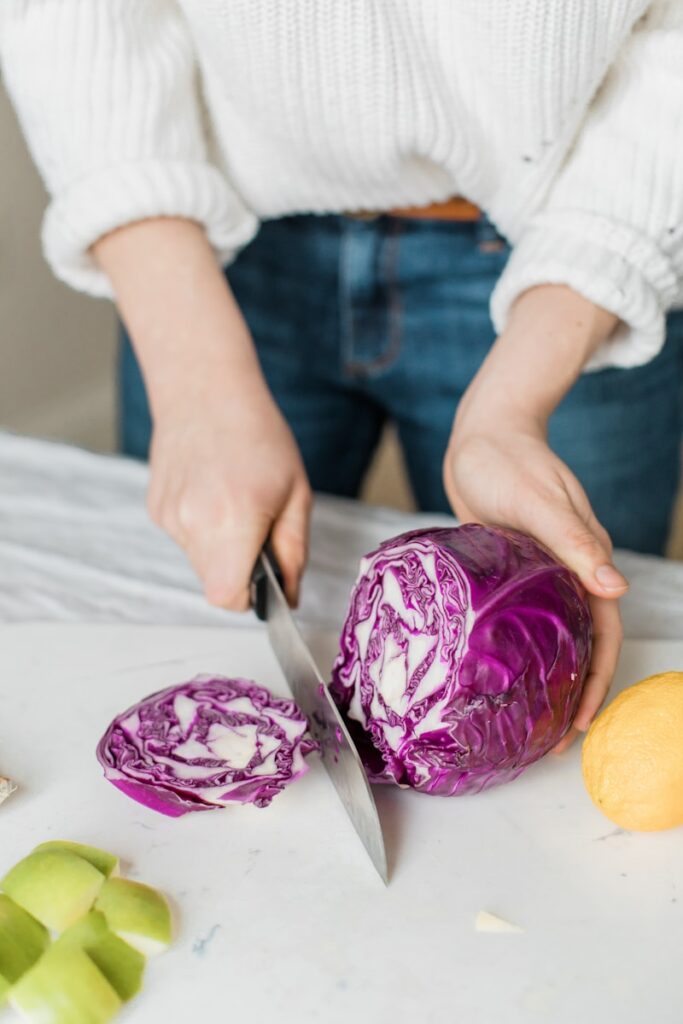 woman slicing purple vegetable Cabbage