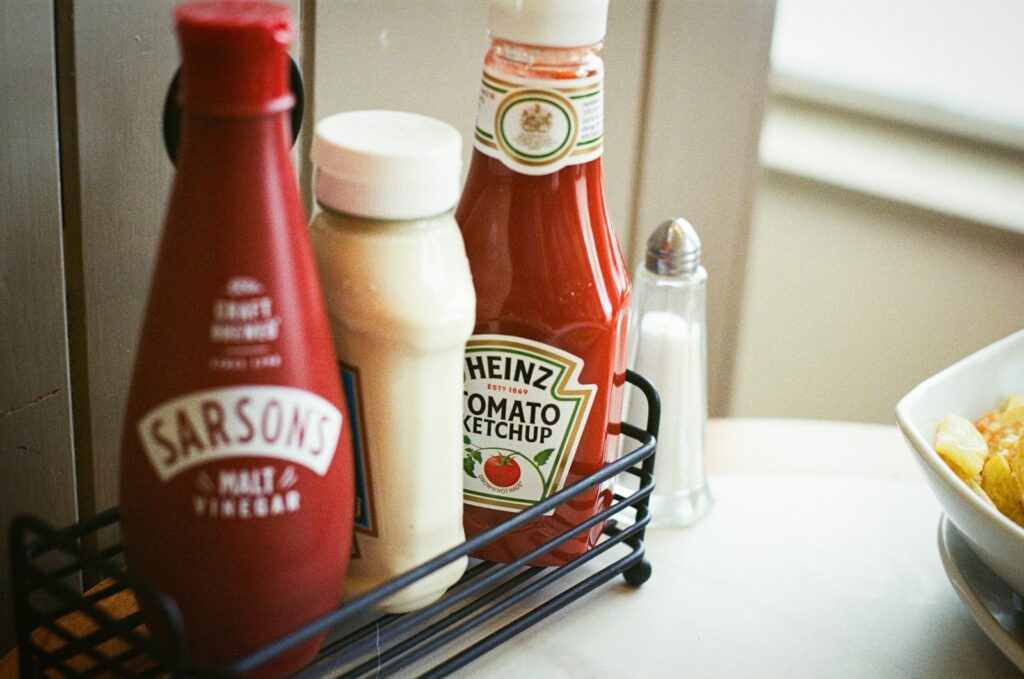 a couple of bottles of ketchup sitting on top of a table