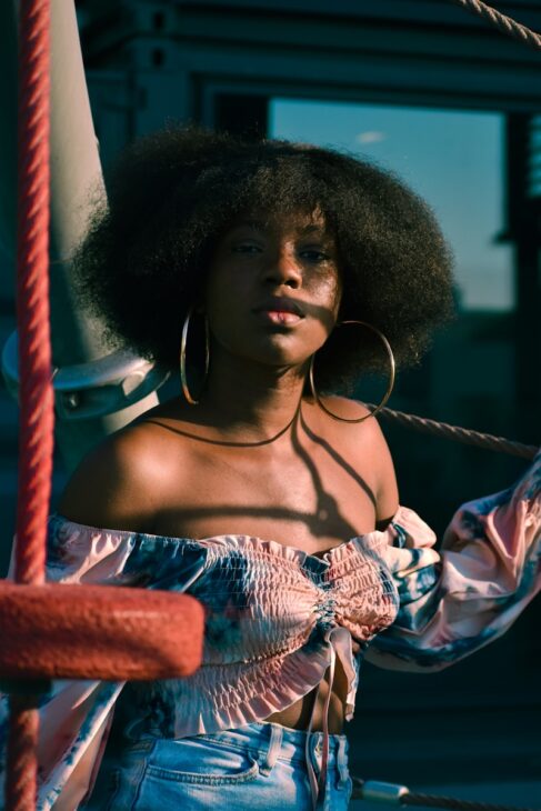 a woman with an afro standing on a boat