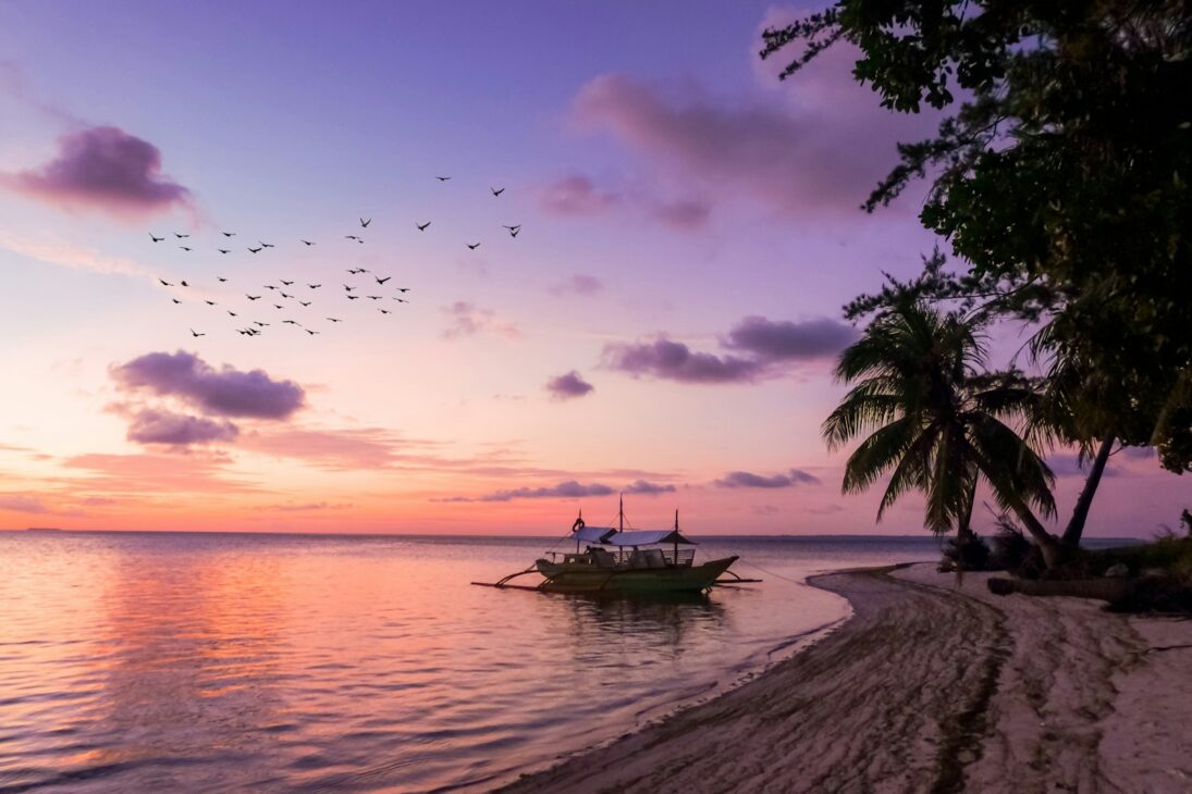 boat on seashore https://placesoflinda.com/philippines-travel-diving-itinerary/