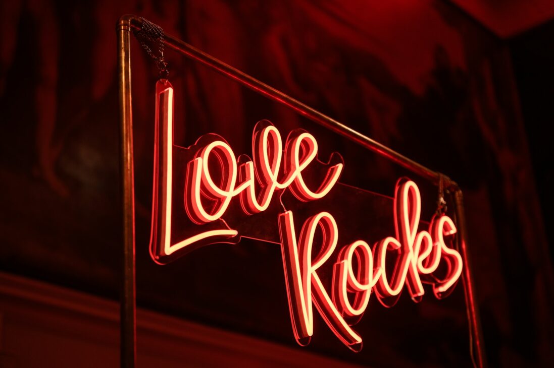 a neon sign that says love rocks on it